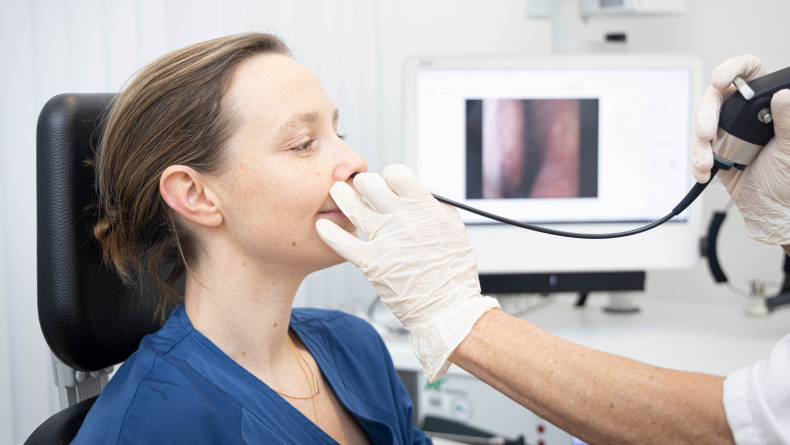 Een vrouw tijdens een laryngoscopie met een fijne en buigzame camera via de neus