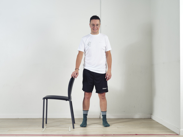 Achter stoel met hand op leuning